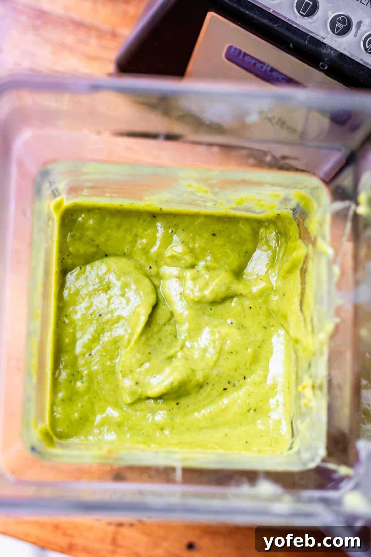 Tangy Tomatillo Enchilada Sauce 17 looking straight down into a blender with blended green enchilada sauce.