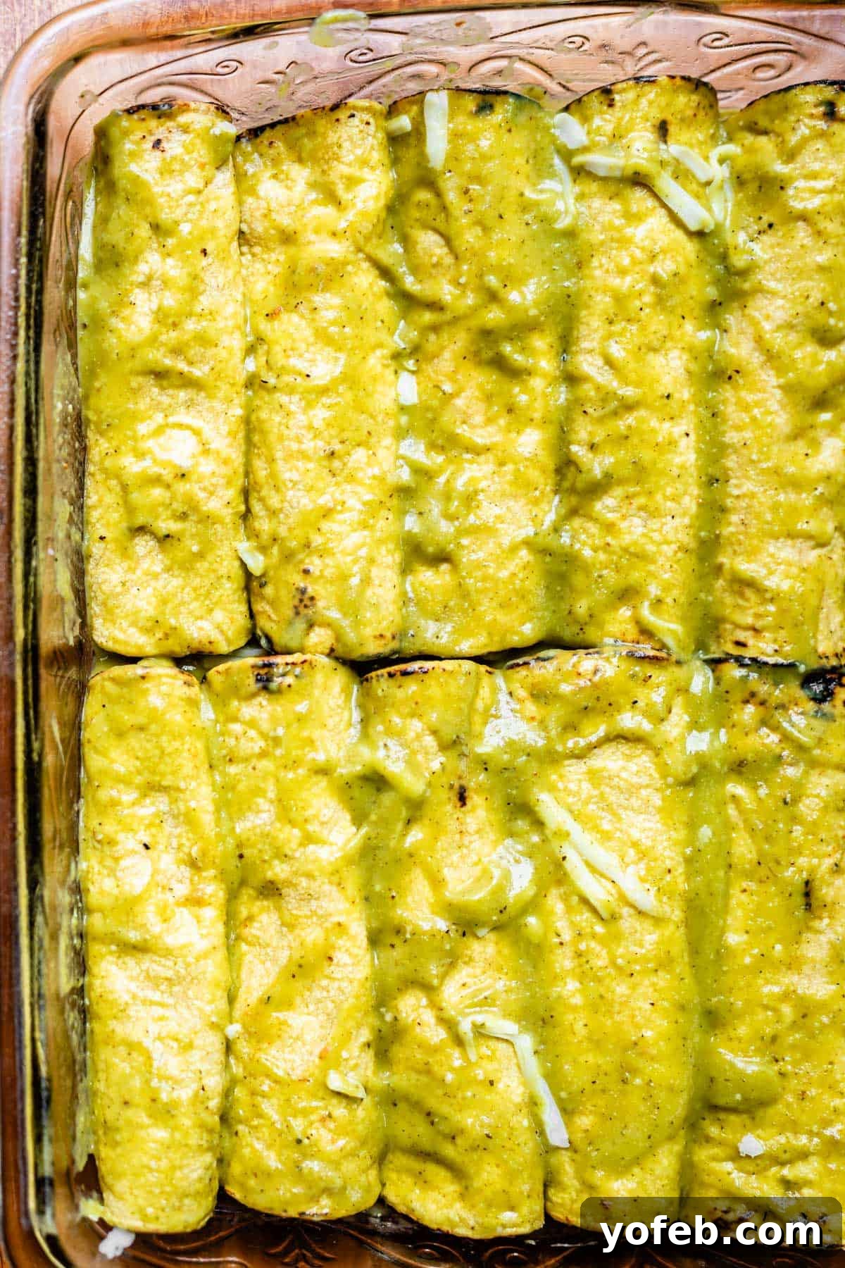 Tangy Tomatillo Enchilada Sauce 4 a glass casserole dish with enchiladas coated in green enchilada sauce.