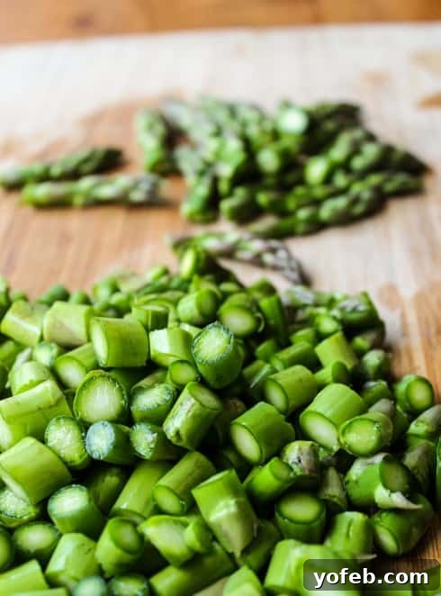 Vibrant Spring Asparagus Puree 7 Fresh asparagus stalks on a wooden cutting board, prepped for soup making.