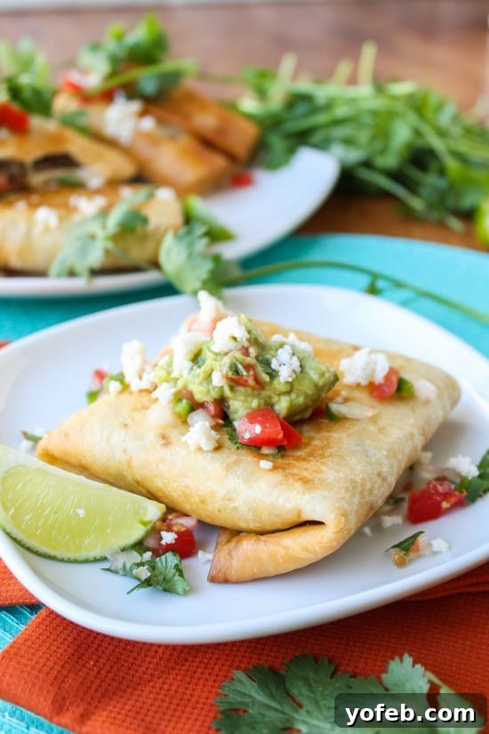 Tangy Tomatillo Chipotle Chicken Chimichangas 6 A plate of freshly fried Chicken, Tomatillo, and Chipotle Chimichangas, garnished and ready