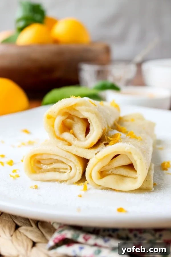 Zesty Meyer Lemon & Cardamom Crepes 2 stack of crepes with meyer lemon and cardamom on white plate.