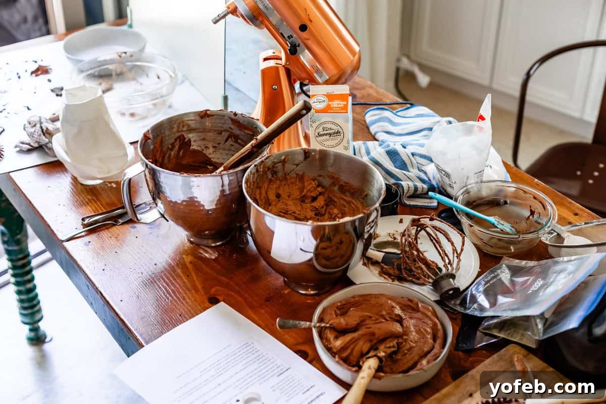 Luscious Chocolate Buttercream: Spoon-Licking Guaranteed 3 a messy kitchen counter with lots of chocolate frosting in various mixing bowls.