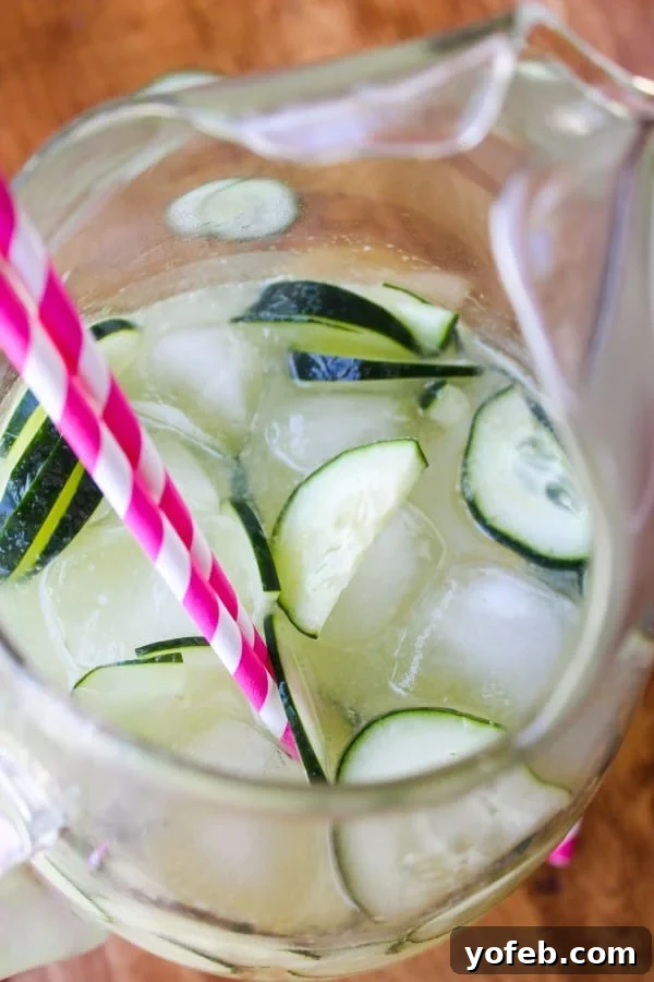 Individual glasses of Easy Cucumber Lime Punch, garnished with fresh cucumber slices.