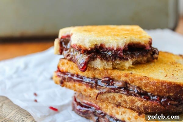 Two slices of bread spread with Nocciolata and raspberry preserves, ready for grilling