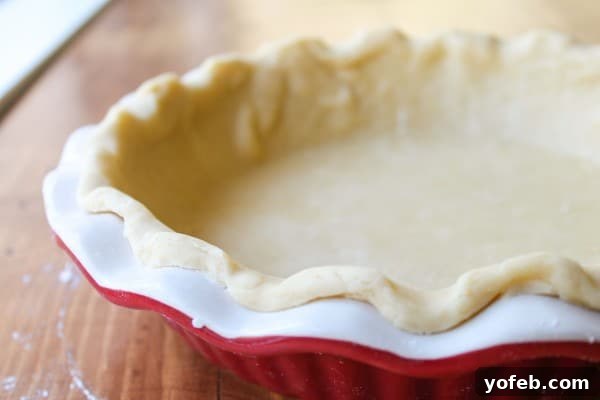 Forming Pie Crust Edges Trimming and forming the edges of the pie dough in the dish.