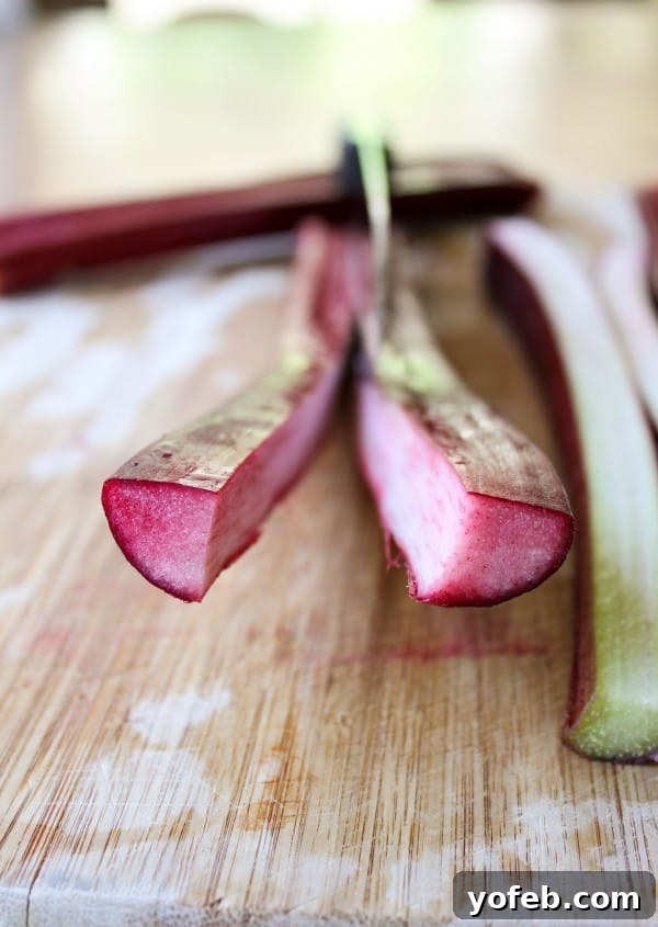 Slicing Rhubarb for Custard Close-up of rhubarb stalks being sliced lengthwise before chopping.