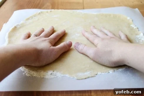Rolling Pie Dough with Parchment Paper Rolling out pie dough between two sheets of parchment paper.