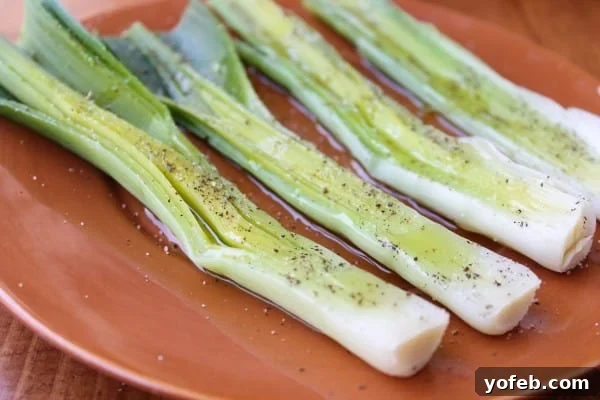 Seasoning boiled leeks with olive oil, salt, and pepper