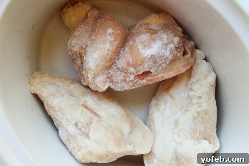 Adding chicken to the crockpot for Cream Cheese Chicken Chili