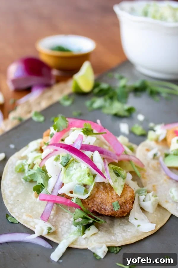 Beer Battered Baja Fish Tacos with Pickled Onions and Slaw Crispy beer-battered fish taco served with fresh cabbage slaw and bright pickled red onions on a warm corn tortilla.