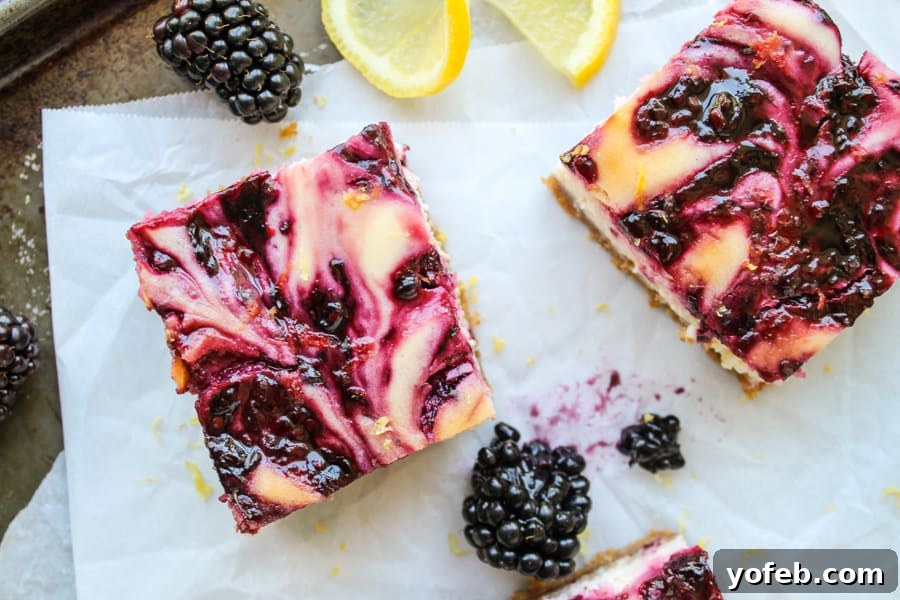 Zesty Lemon Blackberry Squares 3 Several blackberry lemon cheesecake bars arranged neatly on parchment paper, ready to be served.