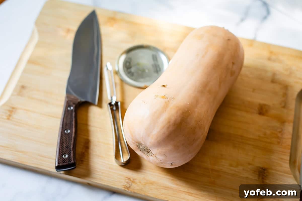 Conquer Butternut Squash: A Simple Guide to Safe Slicing 3 A whole, unpeeled butternut squash, a gleaming chef’s knife, a sharp vegetable peeler, and a sturdy metal jar lid neatly arranged on a rustic wooden cutting board, set against a light, clean kitchen surface.