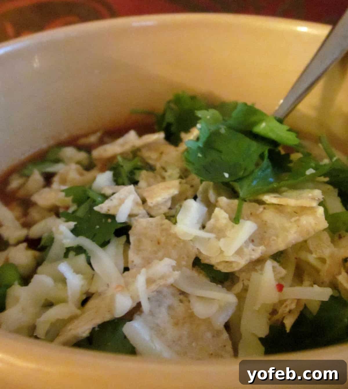 Chicken Taco Soup with Toppings Delicious Slow Cooker Chicken Taco Soup in a bowl, generously topped with cheese, sour cream, cilantro, and tortilla chips