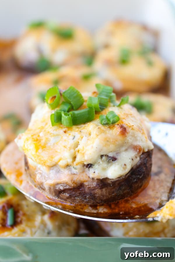 Blazing Blue Cheese & Bacon Stuffed Mushrooms 7 Close-up of a hand gently twisting a mushroom stem to remove it, preparing for stuffing.