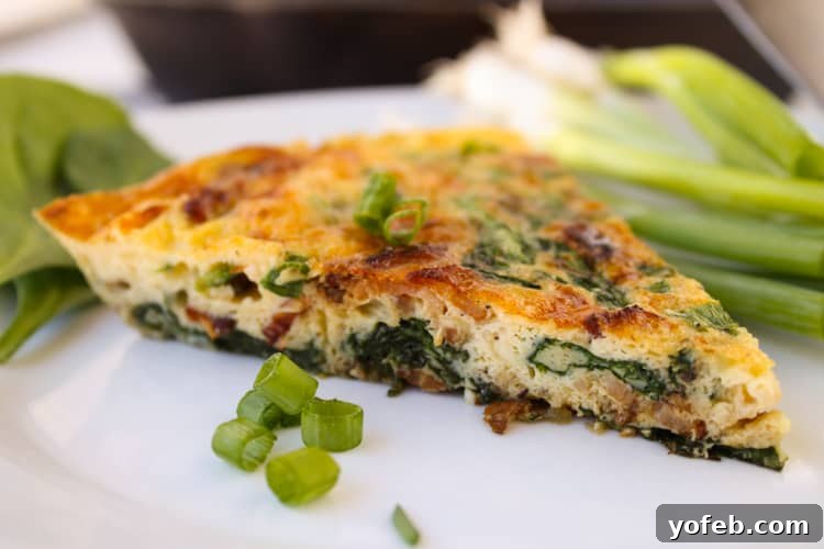 Savory Spinach and Bacon Frittata 3 Bacon frittata on a plate with green onions.