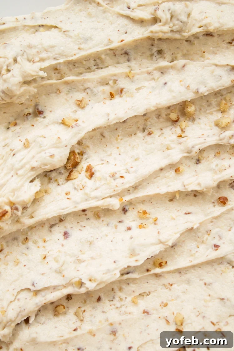 Maple Frosting with chopped pecans, garnishing a festive fall cake.