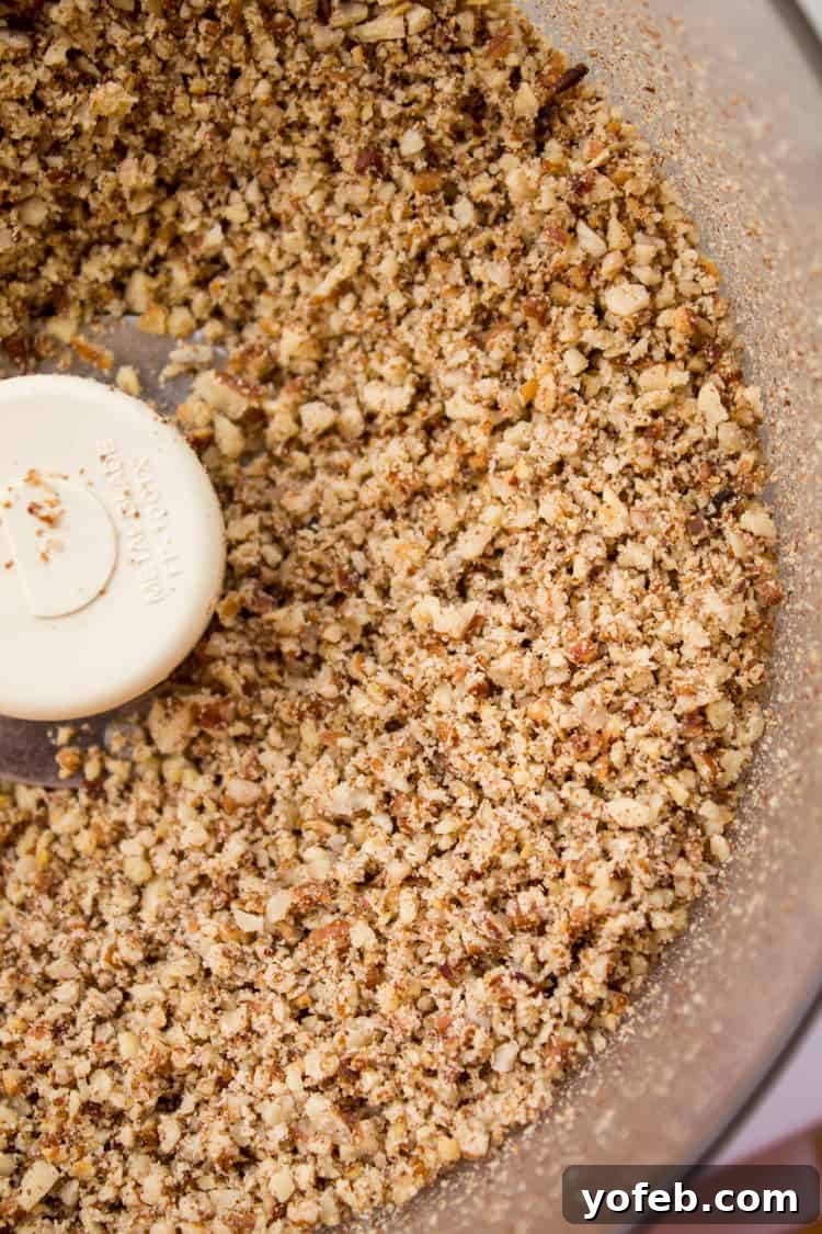 Finely chopped pecans in a food processor, ready for toasting.