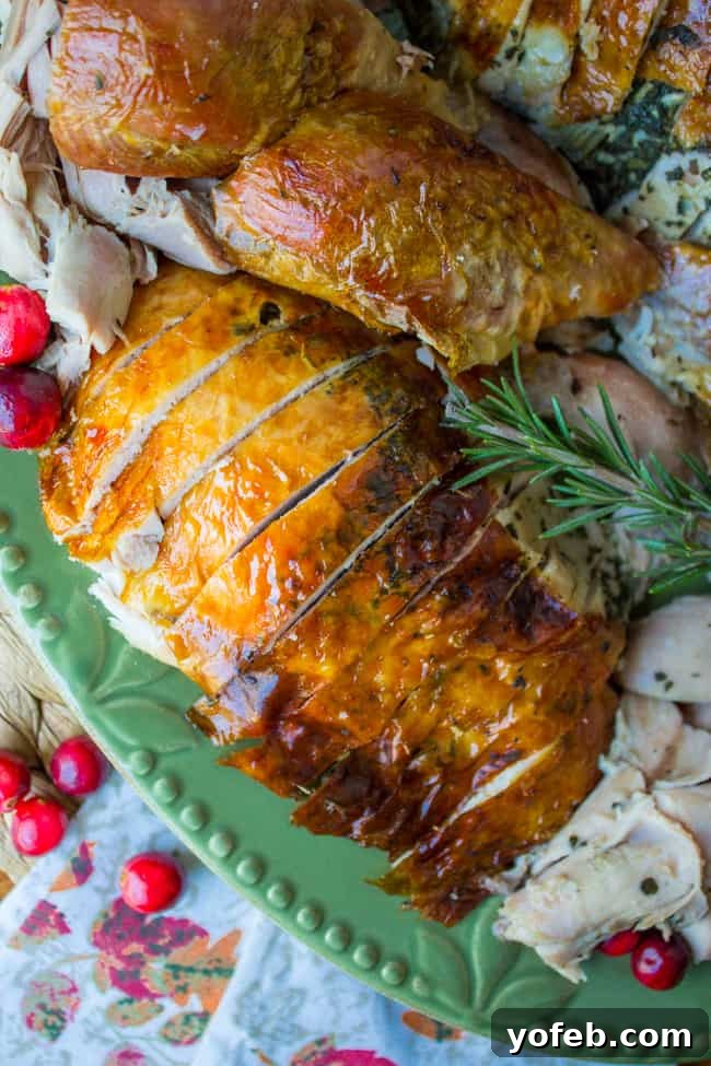 Herbal Roasted Turkey Delights 2 Sliced roast turkey garnished with fresh rosemary and cranberries on an elegant green platter, ready for serving.