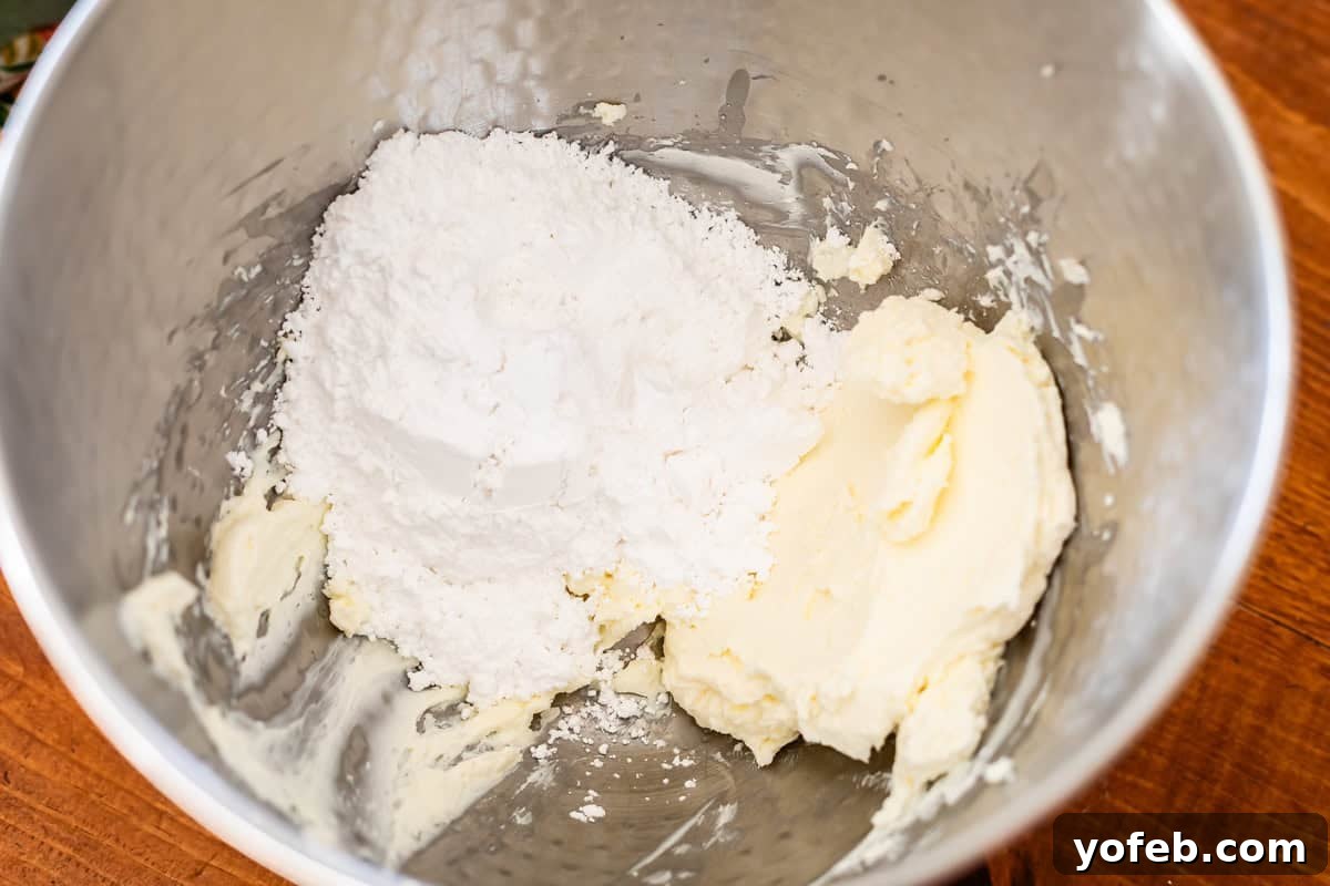 Sweet & Salty Pretzel Delight 11 mixing cream cheese a powdered sugar in a bowl.