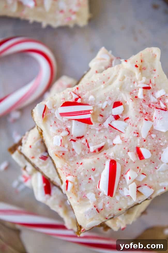 Close-up of a stack of freshly baked Frosted Peppermint Gingerbread Bars, showcasing the soft texture and creamy frosting.