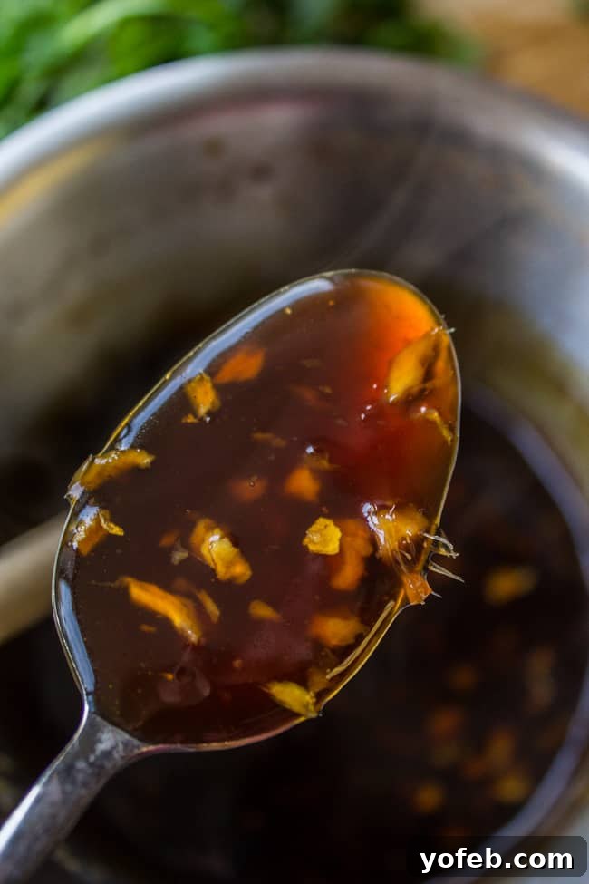 Savory Slow Cooker Asian Pork Tenderloin 3 glaze for pork tenderloin on a spoon above a pot.