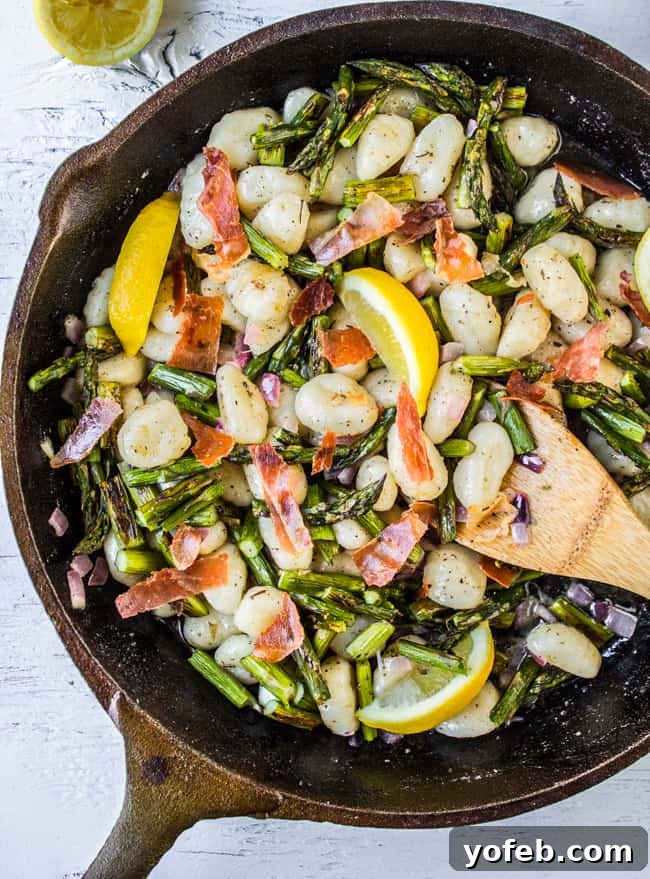 Nutty Brown Butter Gnocchi with Crisp Asparagus 3 A vibrant cast iron pan filled with gnocchi, roasted asparagus, crispy prosciutto, and fresh lemon slices.