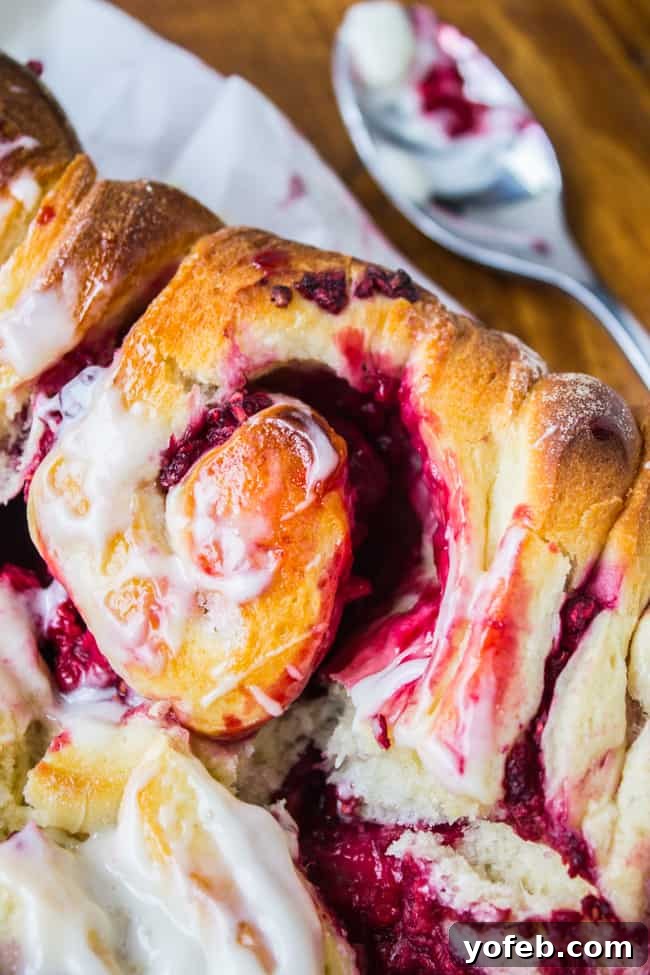 A glorious stack of Raspberry Sweet Rolls with a thick layer of Coconut Cream Cheese Frosting, ready to be enjoyed.