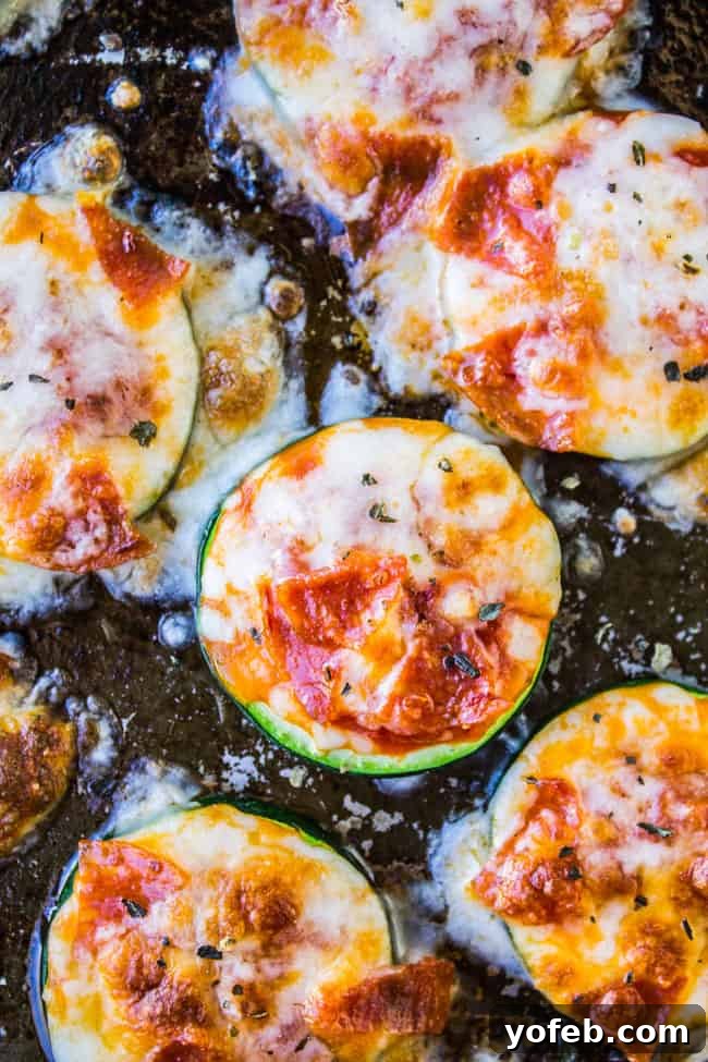 Mini Zucchini Pizzas 3 Freshly baked Zucchini Pizza Bites arranged on a serving plate, showcasing their golden-brown tops