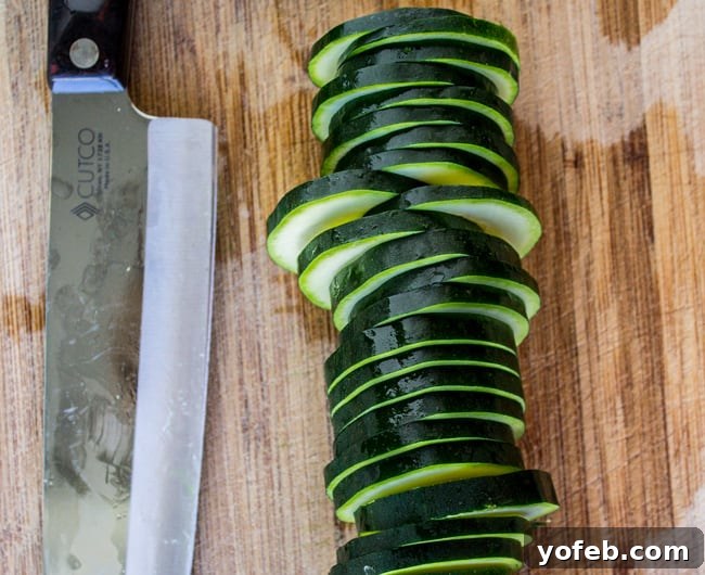 Mini Zucchini Pizzas 5 Fresh zucchini slices ready for preparation on a wooden cutting board