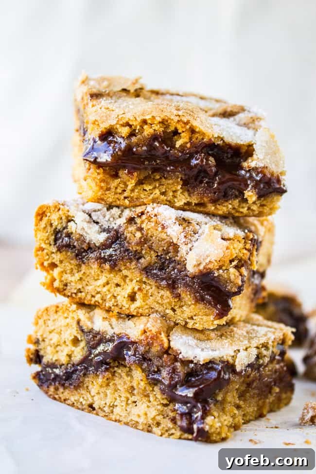 Decadent Peanut Butter Ganache Squares 7 Stack of freshly baked Peanut Butter Ganache Bars, showcasing their gooey centers