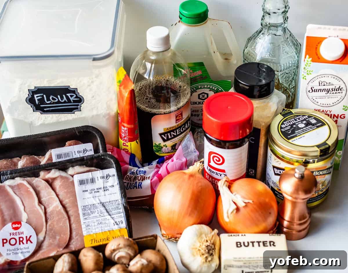 Tender Smothered Pork Chops 6 A variety of cooking ingredients on a counter, including pork chops, onions, garlic, mushrooms, flour, sugar, soy sauce, vinegar, broth, heavy cream, butter, pepper grinder, and seasonings.