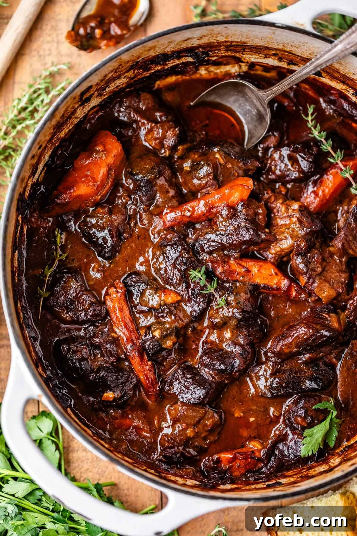 Hearty Irish Beef Stew 20 A pot of rich, hearty beef stew with chunks of beef, carrots, and herbs in a thick brown sauce, garnished with fresh parsley, with a spoon resting inside the pot.