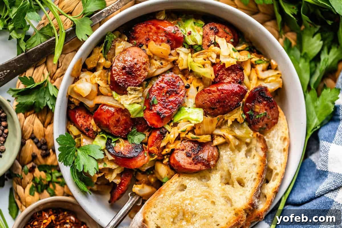 One-Pan Kielbasa and Cabbage Skillet Recipe for Quick Dinners 11 A bowl of sautéed cabbage and sliced sausage garnished with parsley, served with two slices of toasted bread. Fresh herbs and seasonings are scattered around on a woven placemat.