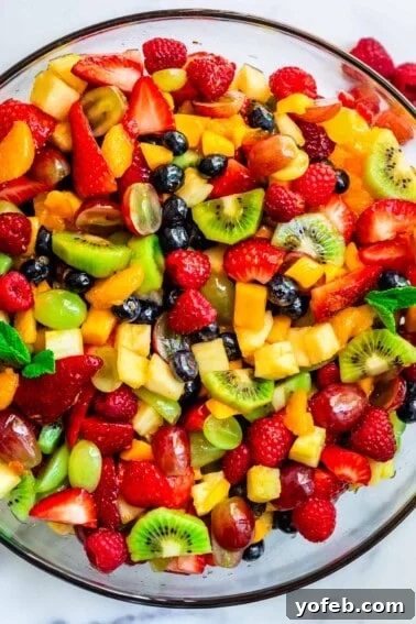 Classic Creamy Coleslaw Recipe with Tangy Dressing 15 glass bowl of fruit salad with kiwi, grapes, strawberries, blueberries, mango, and more.