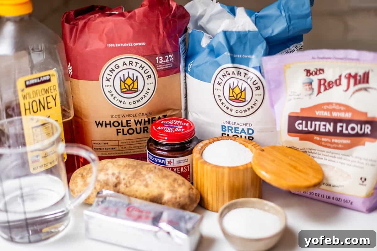 Soft Honey Whole Wheat Bread Recipe 11 Various bread-making ingredients on a countertop, including flours, honey, yeast, butter, a potato, a glass measuring cup, and containers of salt and sugar.